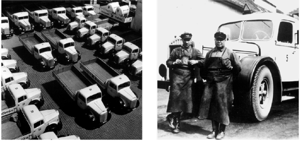 Zwei Männer in Arbeitskleidung stehen neben einem großen Lastwagen.