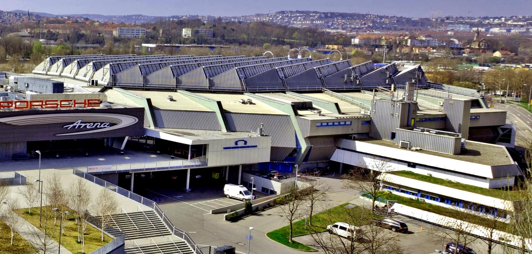 Großes modernes Stadion mit mehreren Eingängen und Solarpanels auf dem Dach.